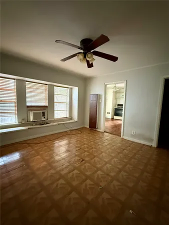 a view of empty room with windows and ceiling fan