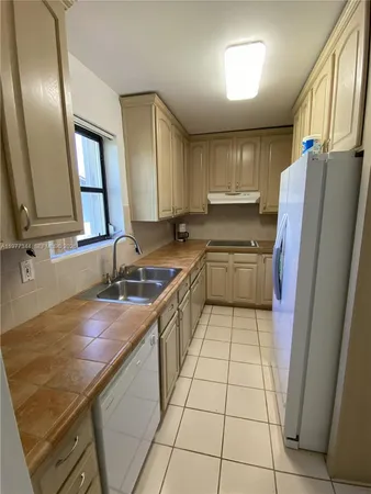 a kitchen with a sink a refrigerator and washer