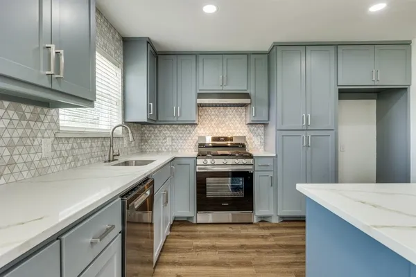 a kitchen with sink a microwave and chairs