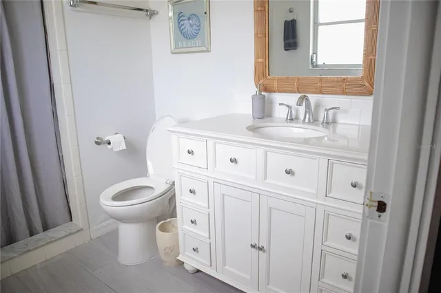 a bathroom with a toilet sink vanity and mirror