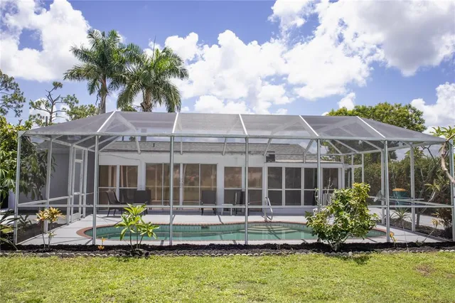 a front view of a house with a garden and swimming pool