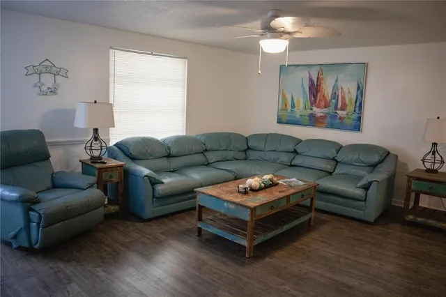 a living room with furniture a wooden floor and a chandelier