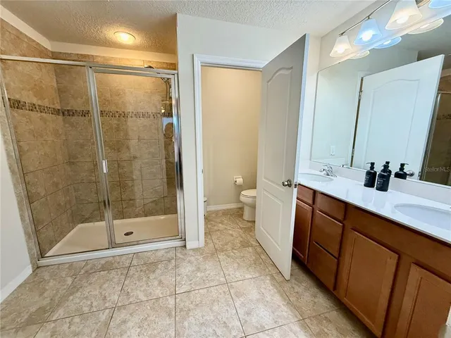 a bedroom with a bed and a flat tv screen on dresser