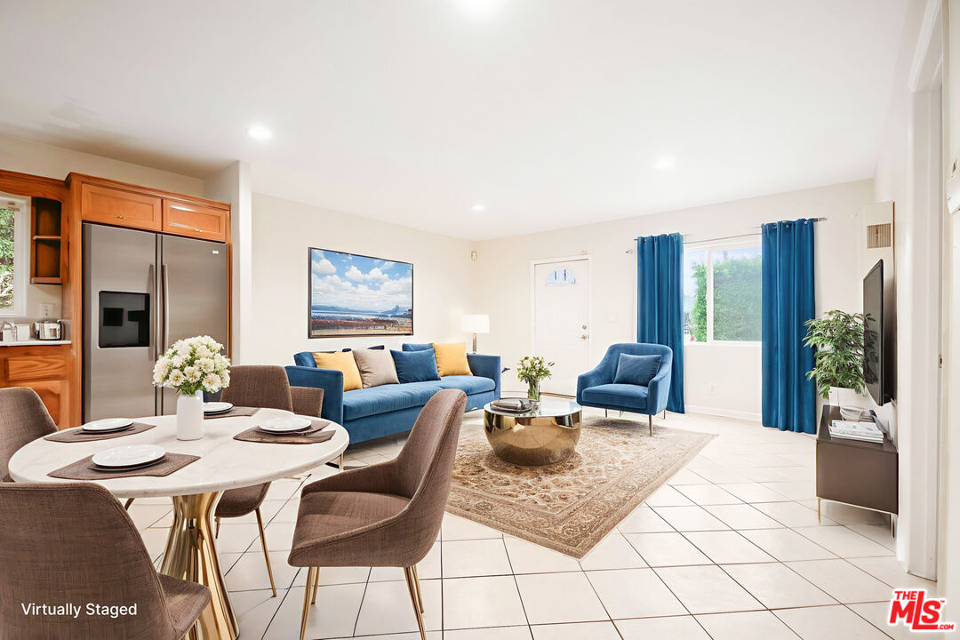 3660 Halldale Avenue Los Angeles, CA 90018 - Photo 3 of 10 a living room with furniture a large window and dining table