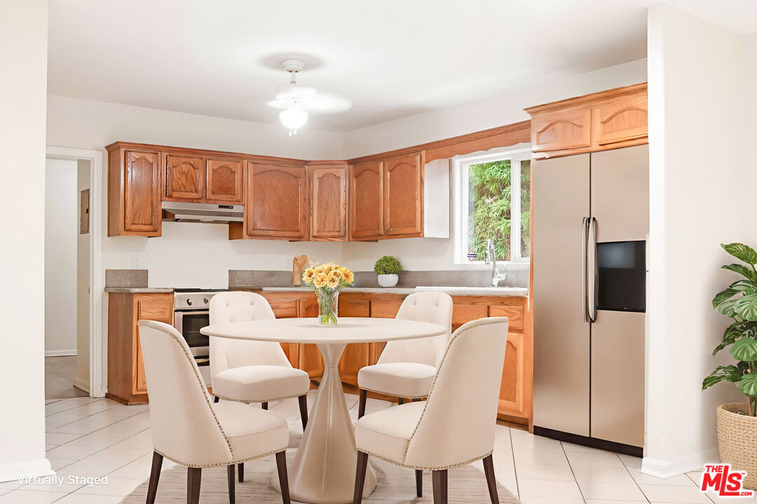 3660 Halldale Avenue Los Angeles, CA 90018 - Photo 5 of 10 a dining room with stainless steel appliances granite countertop a stove a refrigerator a microwave oven with a dining table and chairs