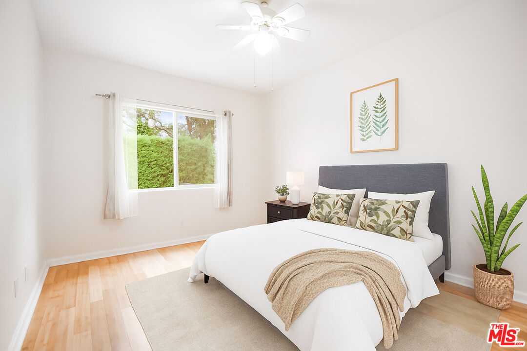 3660 Halldale Avenue Los Angeles, CA 90018 - Photo 6 of 10 a bedroom with a large bed and a potted plant
