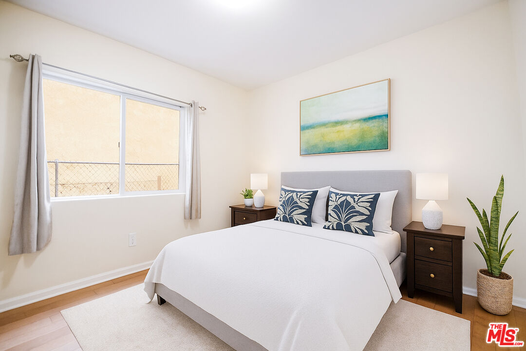 3660 Halldale Avenue Los Angeles, CA 90018 - Photo 8 of 10 a bedroom with a bed and a potted plant