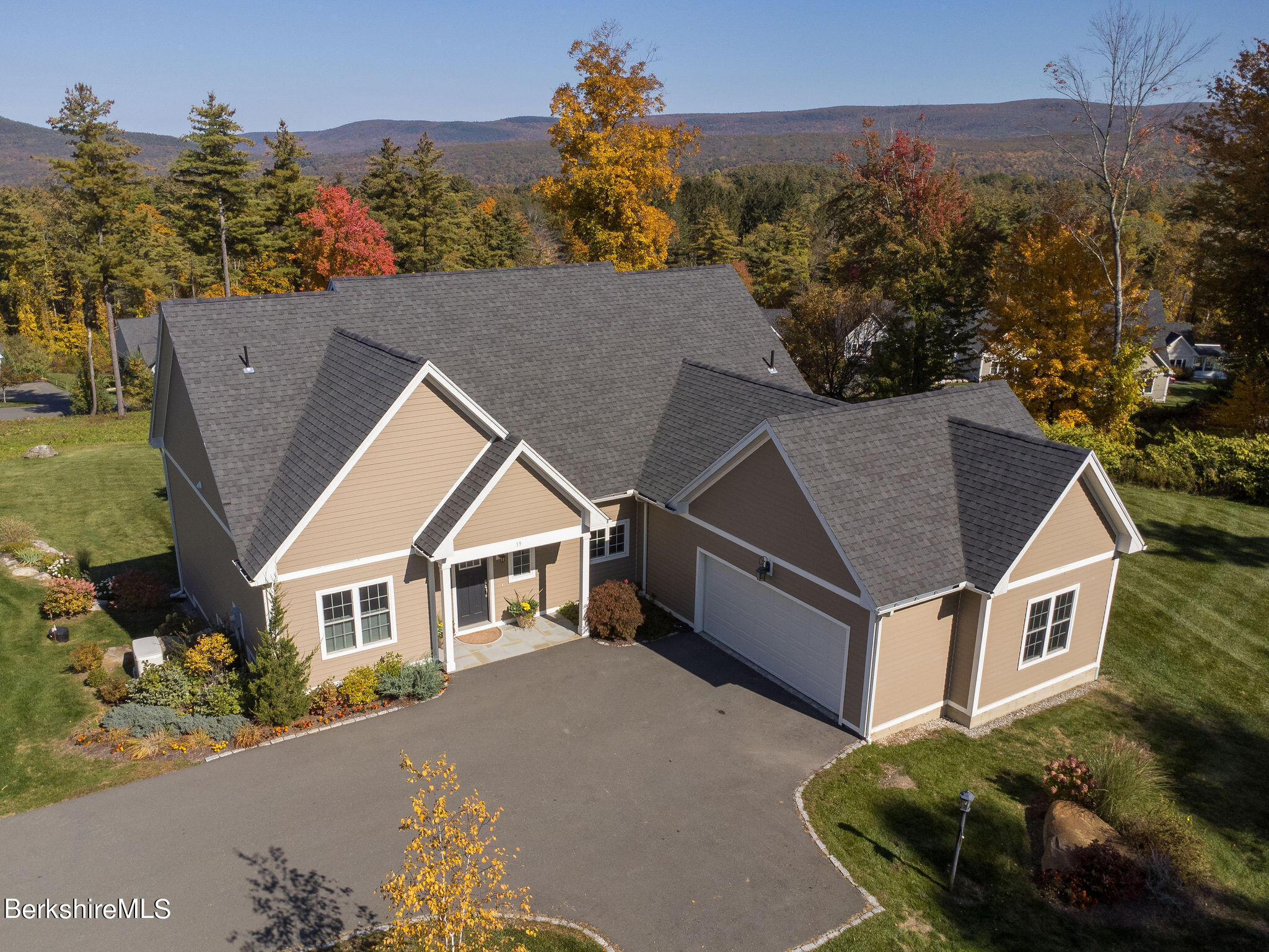 a aerial view of a house next to a yard