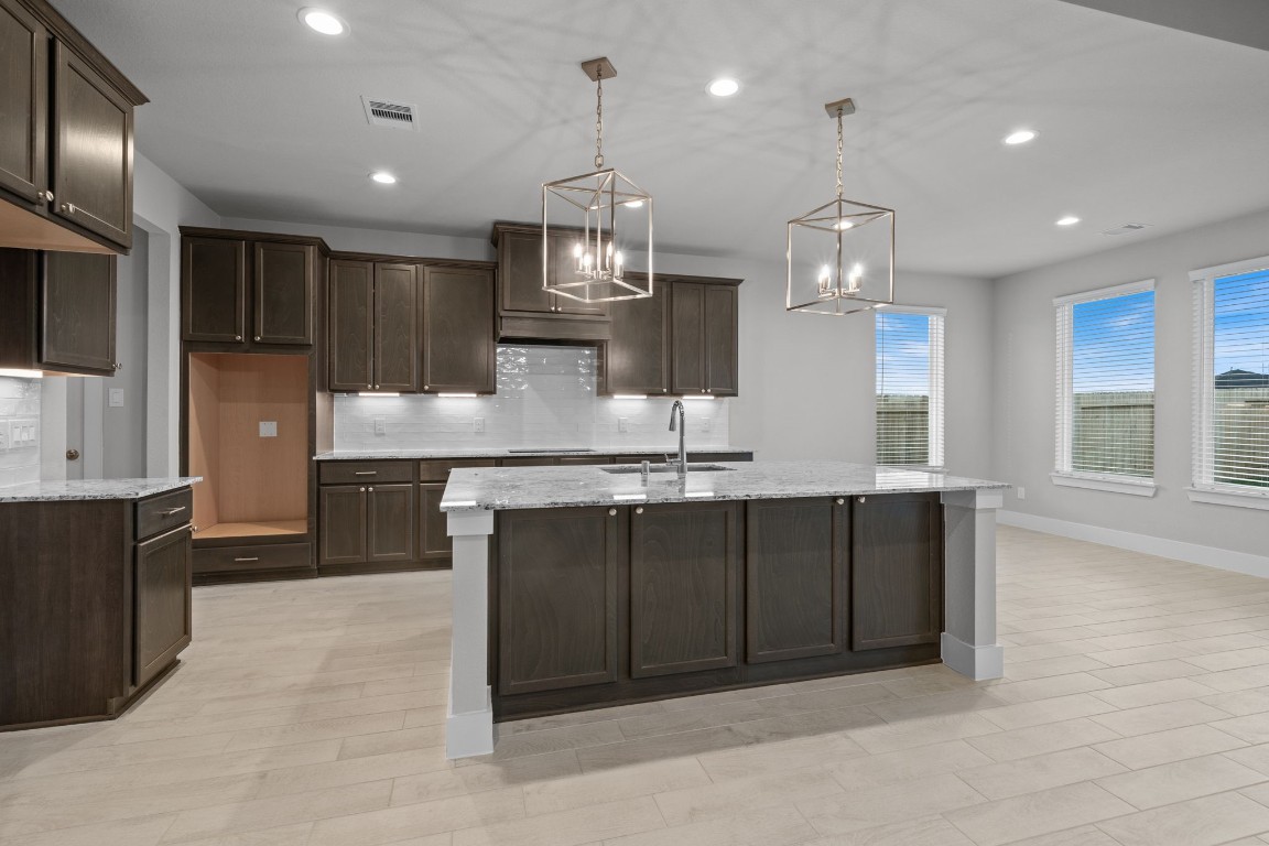 3414 Everglade Lane Rosenberg, TX 77471 - Photo 2 of 29 a large kitchen with a large center island wooden cabinets stainless steel appliances and a counter top space