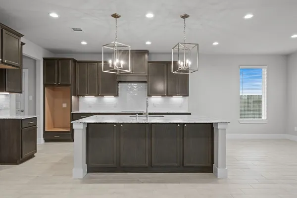 a kitchen with kitchen island stainless steel appliances a sink stove and refrigerator