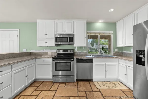 a kitchen with stainless steel appliances a stove sink and microwave