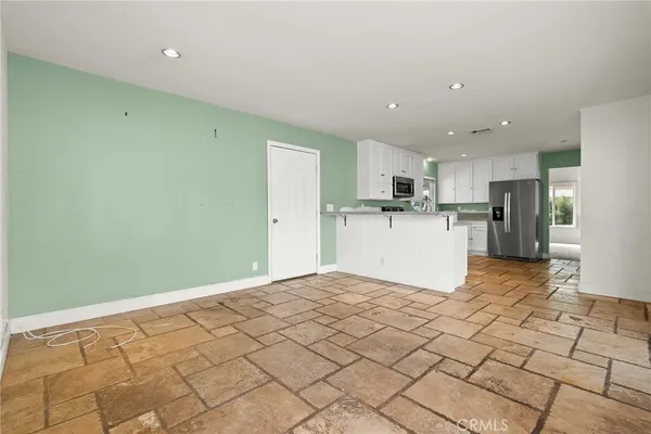a view of a kitchen with a sink and a refrigerator