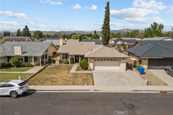an aerial view of a house with a garden and car parked