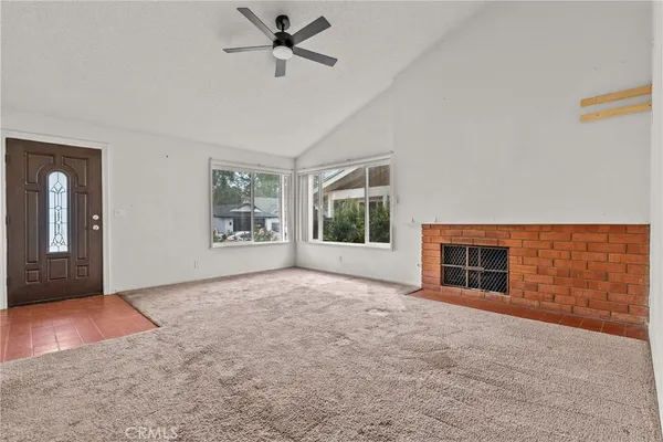a view of an empty room with a window and fireplace