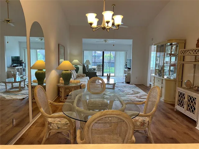 a view of a dining room with furniture a chandelier and wooden floor