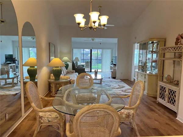 a view of a dining room with furniture a chandelier and wooden floor