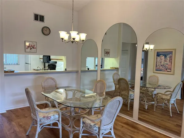 a dining room with furniture a chandelier and wooden floor