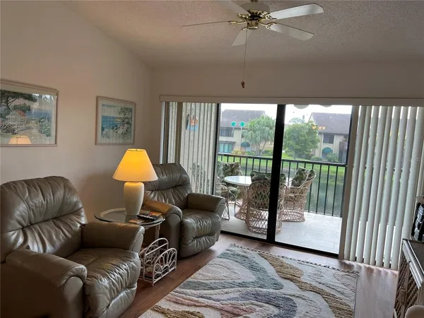 a living room with furniture and a floor to ceiling window
