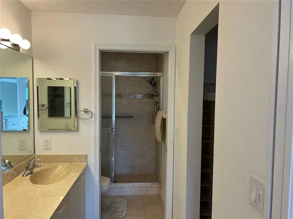 a bathroom with a granite countertop sink mirror and shower