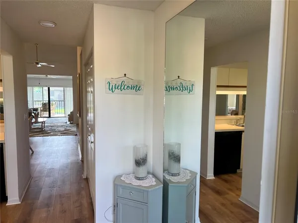 a view of a hallway with bathroom and wooden floor