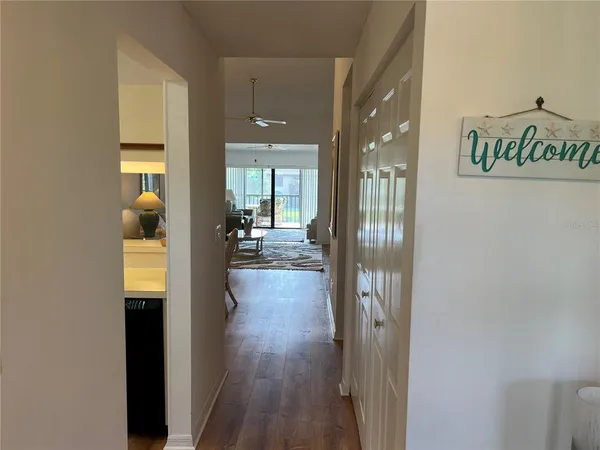 a hallway with wooden floor windows and livingroom