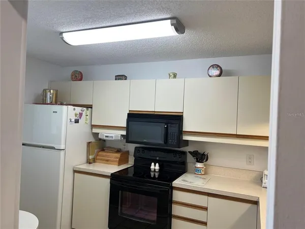 a kitchen with a refrigerator and a stove top oven