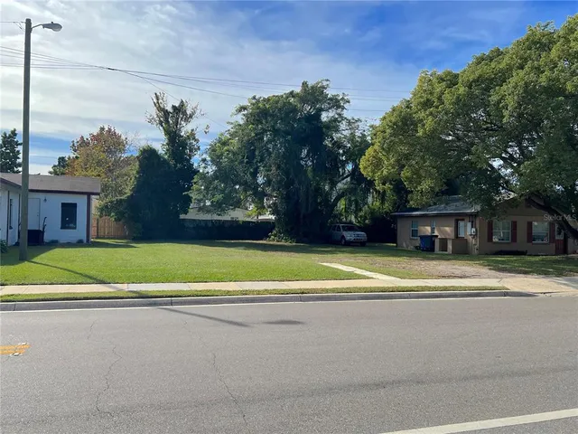 a view of house with outdoor space and trees in the background