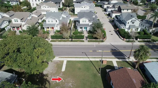 an aerial view of residential houses with outdoor space and trees
