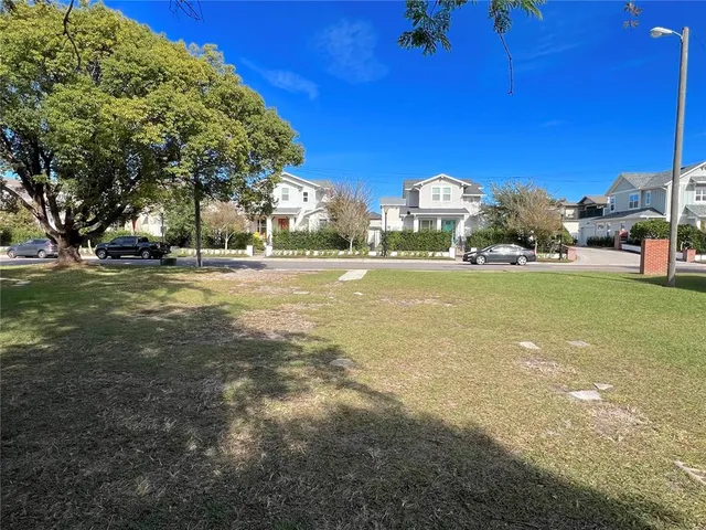 a view of a large house with a big yard and large trees