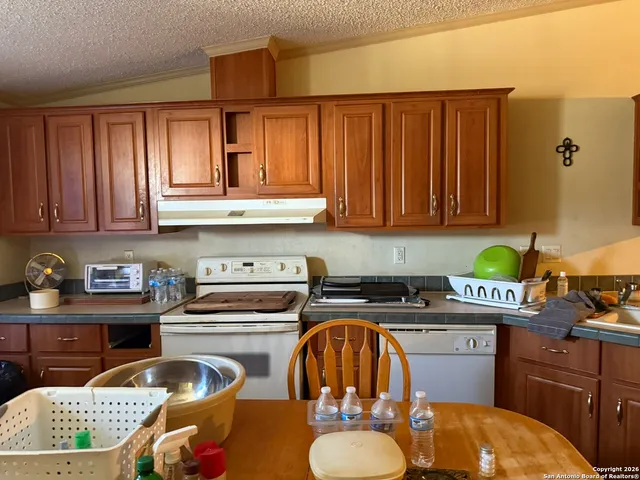 a kitchen with a sink a stove and cabinets