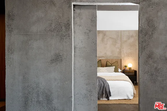 a bedroom with a bed and a lamp on the dresser