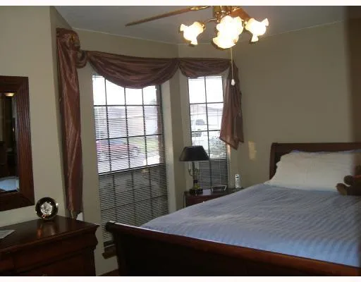 a bedroom with a bed and a flat tv screen on dresser