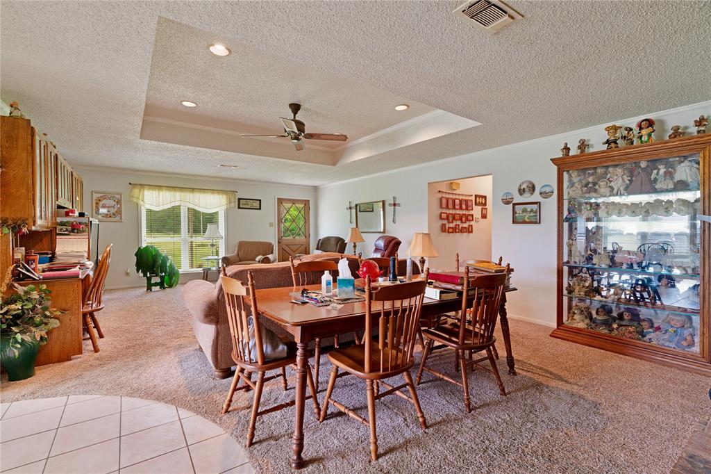 1355 County Road 33100 Sumner, TX 75486 - Photo 23 of 34 Dining room featuring a textured ceiling, light colored carpet, a raised ceiling, a ceiling fan, and crown molding
