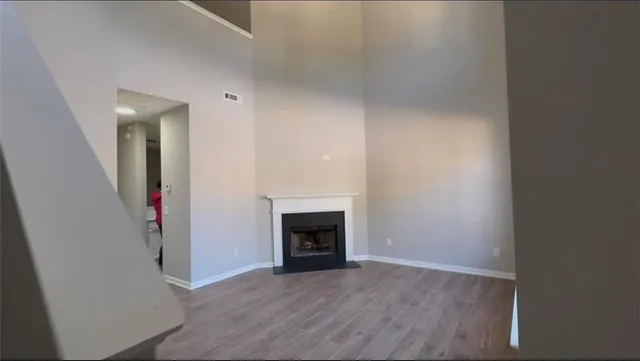 a view of a livingroom with wooden floor and a fireplace