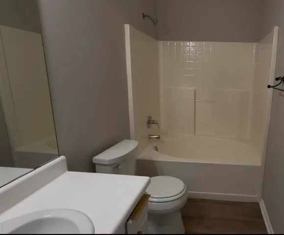 a bathroom with a sink a toilet and a mirror