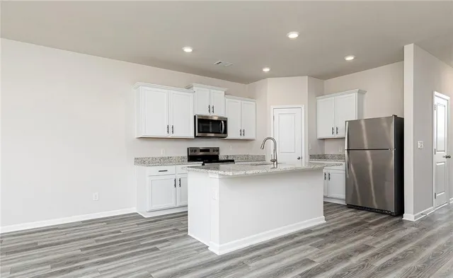 a kitchen with stainless steel appliances a refrigerator sink and microwave