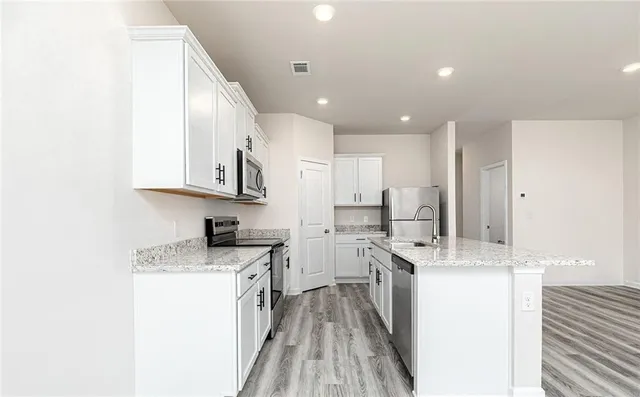 a kitchen with white cabinets appliances and sink