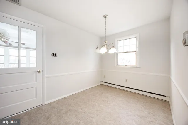 a room with a white wall and a refrigerator