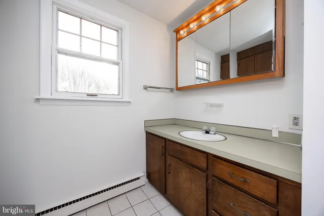 an empty room with windows and chandelier fan