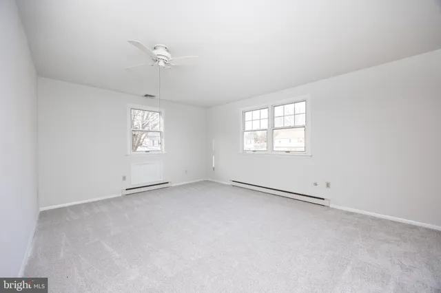 an empty room with windows and closet