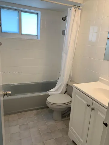 a white toilet sitting next to a bath tub
