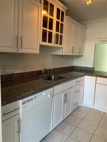 a kitchen with stainless steel appliances granite countertop white cabinets sink and granite counter tops