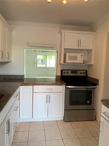 a kitchen with white cabinets and appliances