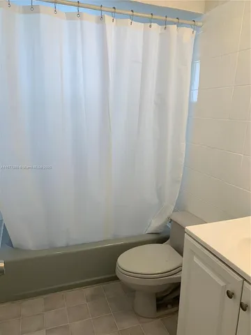 a bathroom with a toilet and a shower curtain