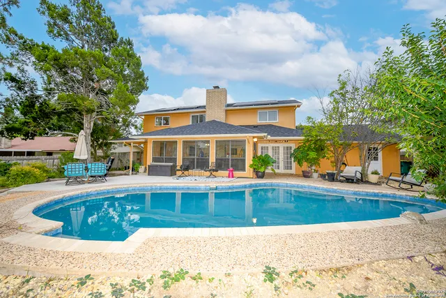 a view of a house with swimming pool and sitting area