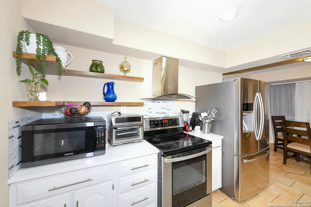 a kitchen with stainless steel appliances a stove microwave and refrigerator