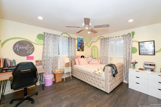 a bedroom with a bed a desk and chair with the mirror