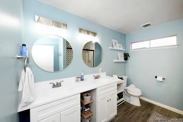 a spacious bathroom with a toilet sink and mirror