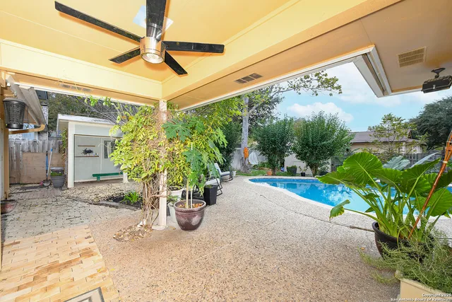 a view of a backyard with plants and a porch