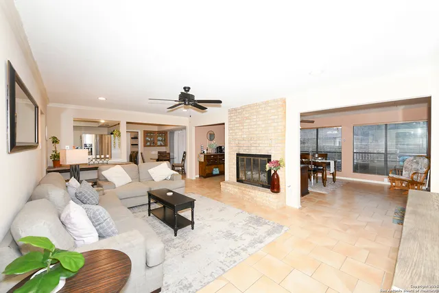 a living room with furniture and a fireplace with wooden floor